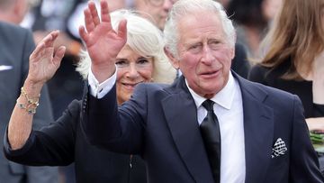 King Charles III and Camilla, Queen Consort wave after viewing floral tributes to the late Queen Elizabeth II outside Buckingham Palace on September 09, 2022