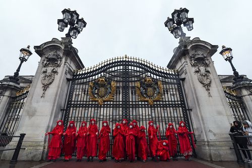 Climate activists pose for the media outside Buckingham Palace during an Extinction Rebellion protest in London, Monday, Oct. 7, 2019. 