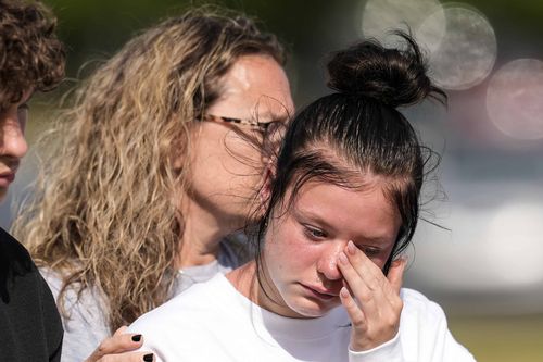 A student weeps at a makeshift memorial after a shooting Wednesday at Apalachee High School,