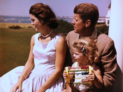 Senator John F. Kennedy relaxes w/ his wife Jacqueline and daughter Caroline.
