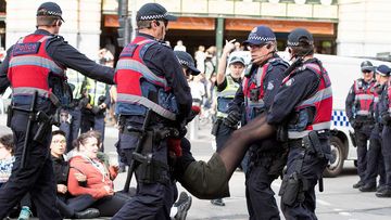 An animal rights protester who had blocked the intersections of Flinders and Swanston Street in Melbourne is removed by police.