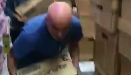 A man is seen grabbing a box of formula before it hits the shelf. (Herald Sun)