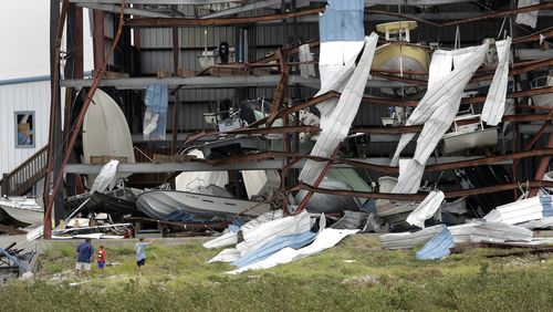 A group stops to check out damage to a boat storage facility in Rockport, Texas. (AP)