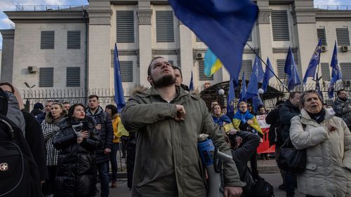 Les gens chantent l'hymne national ukrainien lors d'une manifestation devant l'ambassade de Russie plus tôt cette semaine.