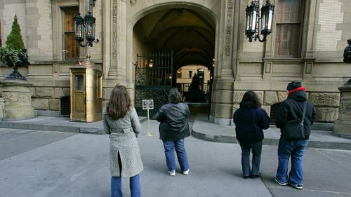 People stand in front of the Dakota apartments where John Lennon was murdered
