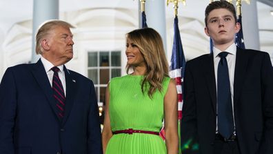 In this Aug. 27, 2020 file photo, Barron Trump right, stands with President Donald Trump and  first lady Melania Trump on the South Lawn of the White House 