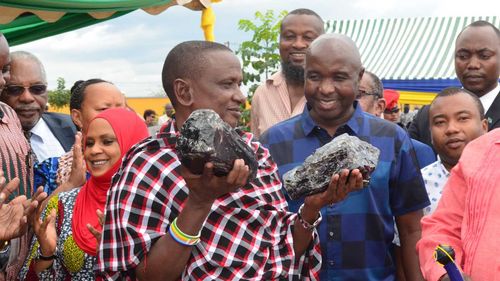 Saniniu Laizer holding the two massive gemstones he dug up.