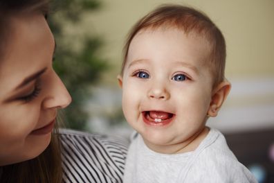 Cute baby girl showing her primary teeth