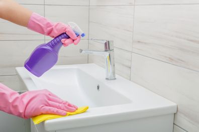 Woman cleaning bathroom at home