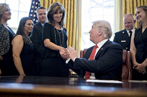 US President Donald J. Trump, right, shakes hands with Tammie Jo Shults, Co-captain of the flight, in the Oval Office in May.