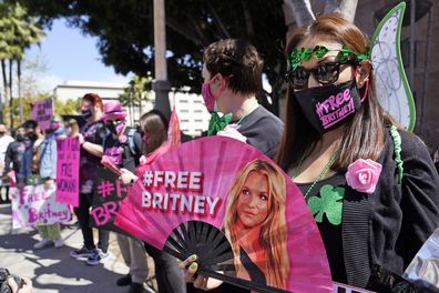 Britney Spears supporter Kiki Norberto holds a hand fan outside a court hearing concerning the pop singer's conservatorship at the Stanley Mosk Courthouse, Wednesday, March 17, 2021, in Los Angeles. Attorneys for Spears and lawyers for her father Jamie Spears jointly asked the judge to delay an accounting and status report on the conservatorship until April 27. (AP Photo/Chris Pizzello)