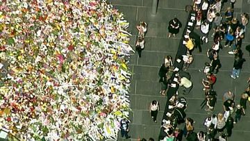 Martin Place has been flooded in a sea of colour as people share in their grief for the victims and hostages of the Lindt cafe siege. (9News)