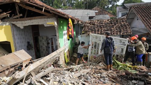 Rescuers help clear up debris from the ruins of a house damaged during Monday's earthquake in Cianjur, West Java, Indonesia, Wednesday, Nov. 23, 2022. 