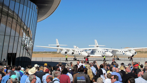 In this Oct. 17, 2011, file photo a crowd gathers outside Spaceport America for a dedication ceremony as Virgin Galactic's mothership WhiteKnightTwo sits on the tarmac near Upham, New Mexico.