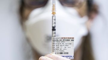 Staff preparing Pfizer vaccine doses inside the Melbourne Showgrounds COVID-19 Vaccination Centre.