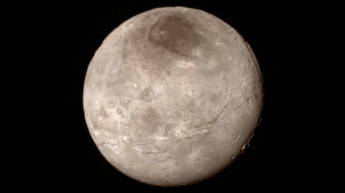 This new photo of Charon, one of Pluto's moons, shows a swath of cliffs and troughs stretching about 1000 kilometers from left to right, and a canyon estimated to be seven to nine kilometers deep. (NASA)
