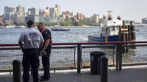 Police at the spot where the baby was found in the New York river.