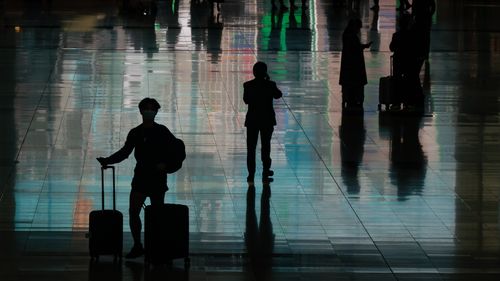 여행자들이 2022년 12월 30일 중국 홍콩의 홍콩 국제공항 도착장에서 수하물을 들고 걸어갑니다. 