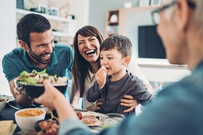 Happy family eating at table.