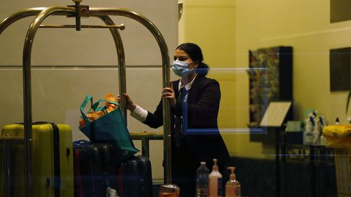 Staff inside a hotel in Melbourne are seen moving luggage for guests in quarantine. 