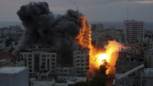 A ball of fire and smoke rise from an explosion on a Palestinian apartment tower following an Israeli air strike in Gaza City.