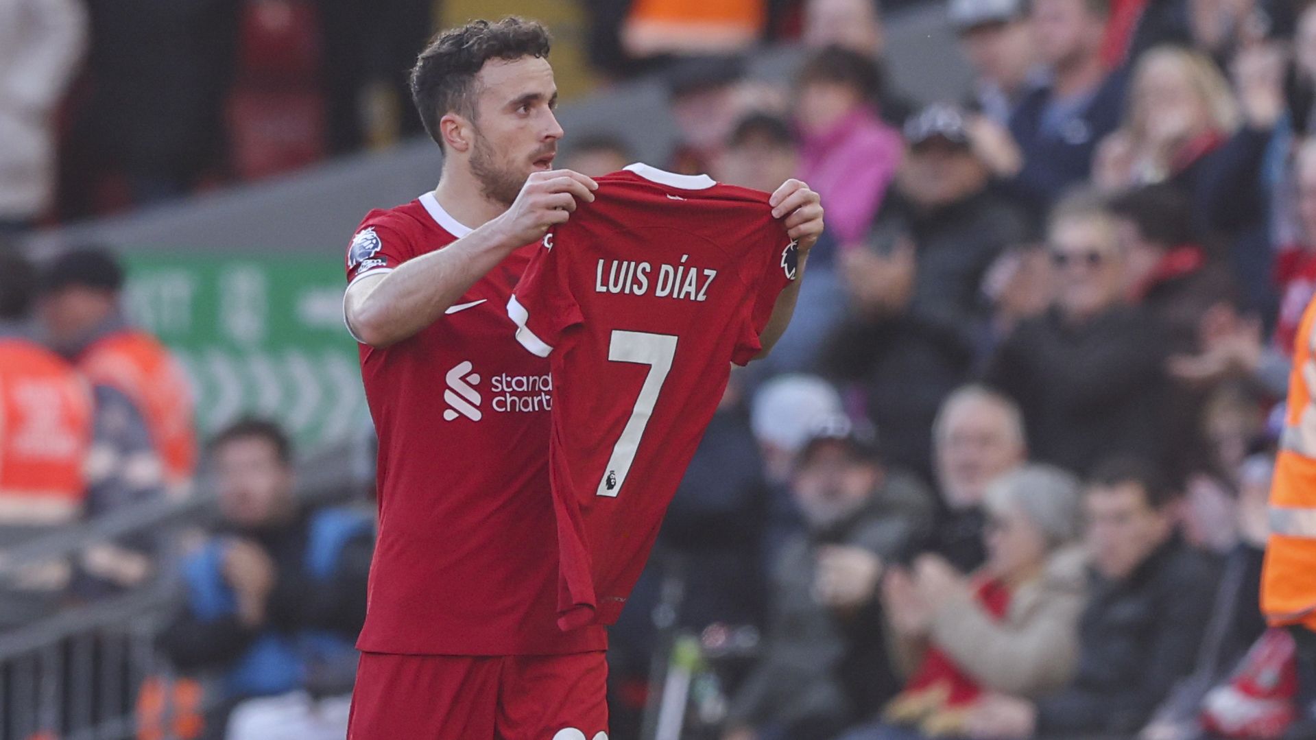 Liverpool&#x27;s Diogo Jota holds up the shirt of teammate Luis Diaz in tribute.