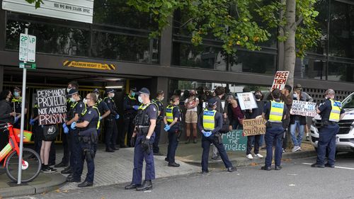 Police surround refugee advocates at the Park Hotel, used as an immigration detention hotel where Serbian tennis player Novak Djokovic is confined in Melbourne, Australia.