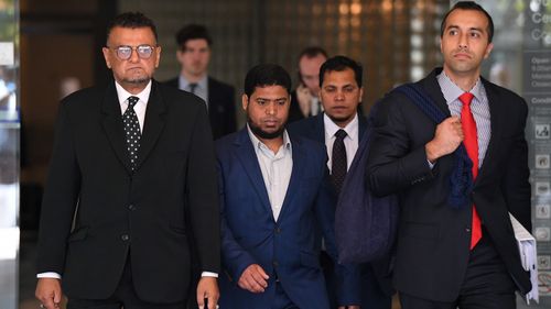 Uber driver Nazrul Islam (centre) leaves the Downing Centre Court in Sydney. Islam, 31, has pleaded not guilty to negligent driving occasioning death after a 30-year-old passenger left his car and was hit by a bus at 3.14am on June 17 in 2017 in Sydney's CBD.