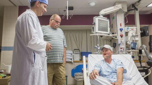 Andy Sandness with doctors before his surgery.