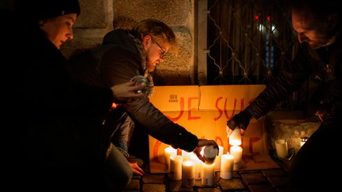 People light candles in front of the French Embassy in Copenhagen, Denmark as mark of respect to those killed in the Charlie Hebdo shooting. (AAP)