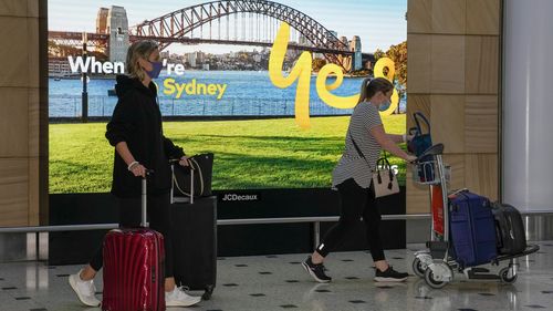 Passengers arrive early morning at Sydney Airport, Monday, Nov. 29, 2021. Authorities in Australia said Sunday, Nov. 28, 2021, that two travelers who arrived in Sydney from Africa became the first in the country to test positive for the new variant of the coronavirus, omicron. (AP Photo/Mark Baker)