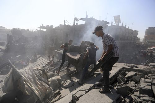 Palestinians inspect the rubble of destroyed buildings following Israeli airstrikes on town of Khan Younis, southern Gaza Strip, Thursday, Oct. 26, 2023 
