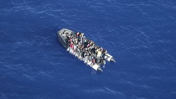 In this handout photo released by German non-governmental organisation Sea-Watch on Tuesday, Oct. 25, 2022, migrants attempting to cross the Mediterranean Sea on a rubber boat to Europe are seen during an interception by a Libyan coast guard ship in international waters. (Fiona Alihosi/Sea-Watch via AP)