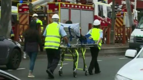 Emergency services helping the injured after man sets himself on fire in Springvale Commonwealth Bank branch.