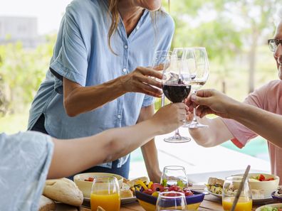 Happy family toasting wine glasses while sitting at table for lunch