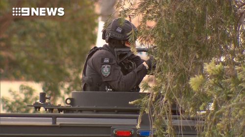 A heavily armed officer outside the Punchbowl house.