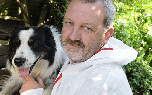 Mick Swindells, a former police officer with Lancashire Police, is photographed alongside one of his cadaver dogs.