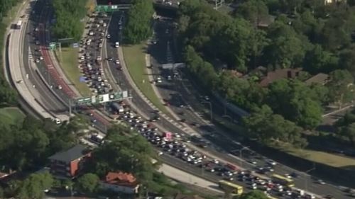 Traffic queued back 13 kilometres to Naremburn after truck crash in Moore Park covers road in debris