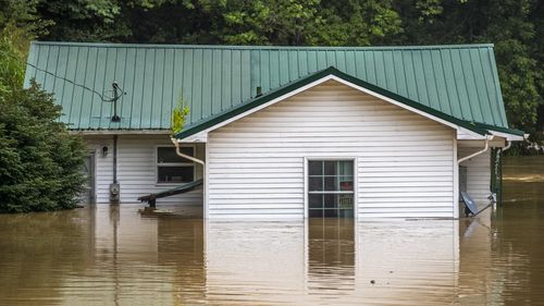 Homes are flooded by Lost Creek, Ky., on Thursday, July 28, 2022.  Heavy rains have caused flash flooding and mudslides as storms pound parts of central Appalachia. Kentucky Gov. Andy Beshear says it's some of the worst flooding in state history.  (Ryan C. Hermens/Lexington Herald-Leader via AP)