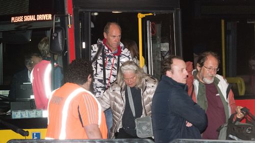 Tourists and locals disembark a bus at the Horncastle Arena in Christchurch after being evacuated by the HMNZS Canterbury Naval ship from Kaikoura. (AFP)