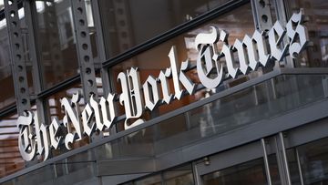 A sign for The New York Times hangs above the entrance to its building