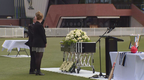 O caixão de Ben, adornado com o logotipo do Collingwood Football Club, foi exibido ao lado de um arranjo floral com seu nome.