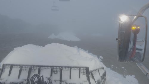 A snow plough is preparing snow at Mount Buller.