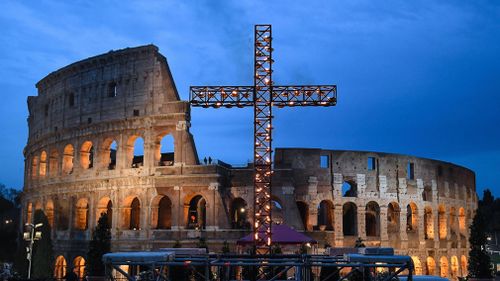 A candle-lit cross stands outside the ancient Colosseum in Rome, Italy. (EPA)