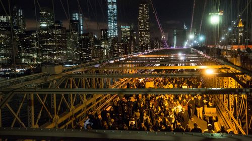 Protesters walk across the Brooklyn Bridge in New York during the National March Against Police Violence. (Getty)