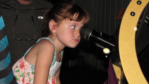 Elizabeth Myers gazes through a telescope. (AAP)
