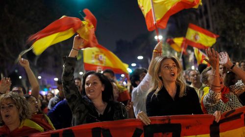 Anti-independence supporters shout slogans and wave Spanish flags as they march against the unilateral declaration of independence. (AP)