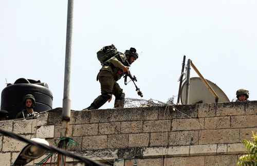 Israeli army take position during clashes with Palestinian stone throwers in the West Bank city of Hebron. Picture: EPA