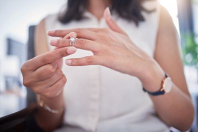 Woman taking off her engagement / wedding ring