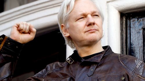 WikiLeaks editor Julian Assange appears on the balcony of the Ecuadorian embassy in London after Swedish authorities dropped their rape investigation. (AAP)